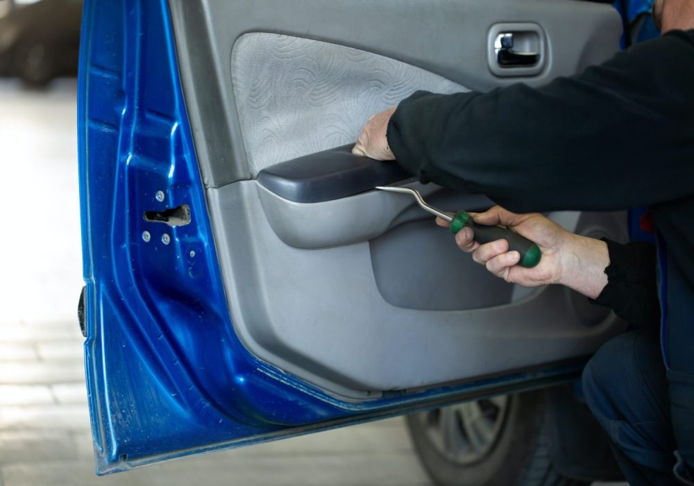 An auto mechanic repairs the interior of the car